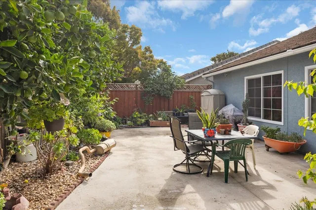 a view of a patio with table and chairs and potted plants