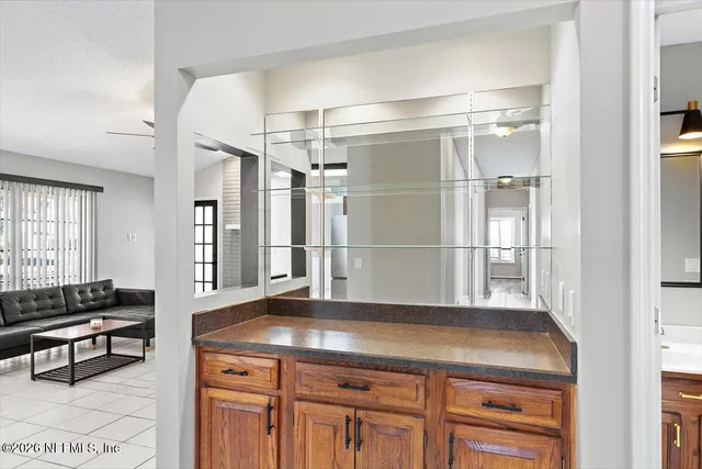 a kitchen with kitchen island a counter top space wooden floor and a refrigerator