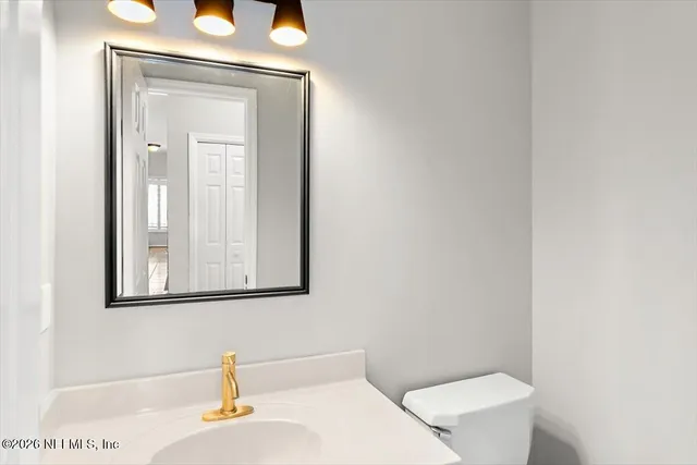 a bathroom with a toilet sink and mirror