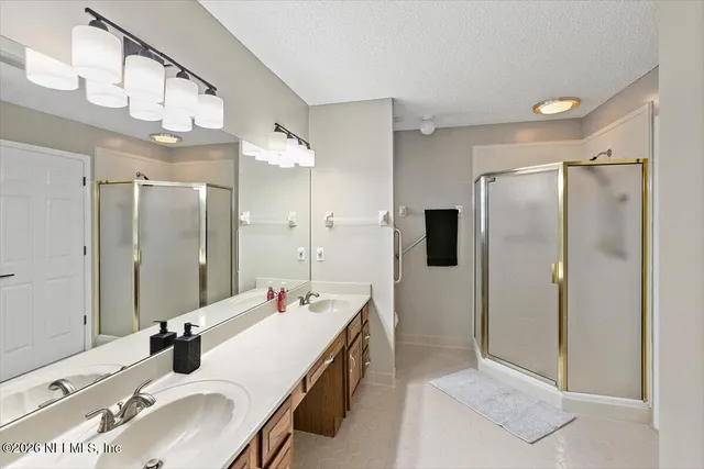 a bathroom with a double vanity sink mirror and shower