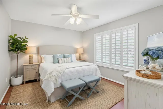a bedroom with a bed and a table chair with the potted plant