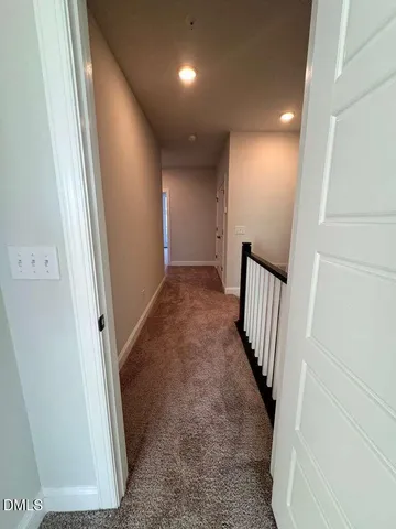 a view of a hallway with wooden floor and a cabinet