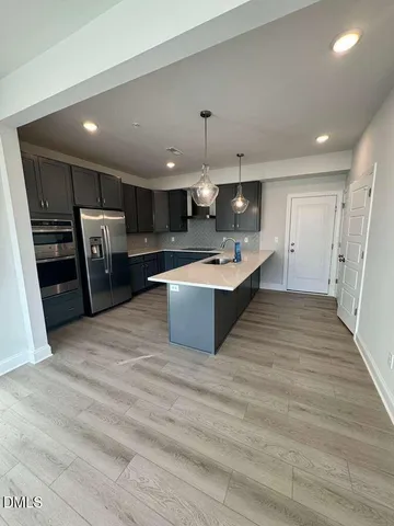 a large kitchen with stainless steel appliances a large counter top