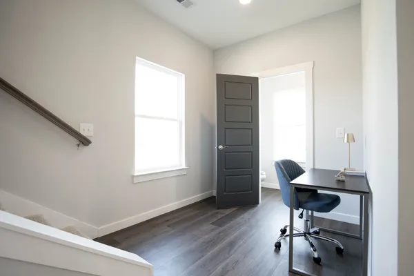a view of a workspace with furniture and a window