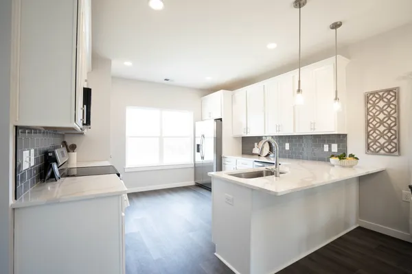 a kitchen with a sink a stove a refrigerator and cabinets