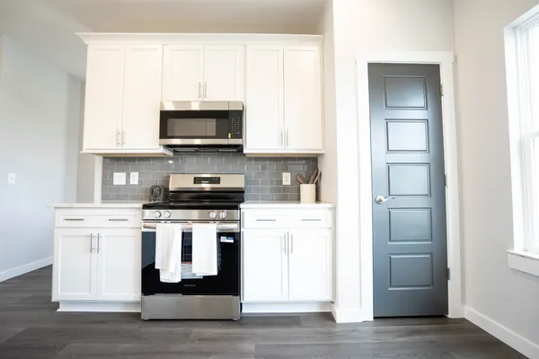 a kitchen with stainless steel appliances granite countertop a stove and a microwave