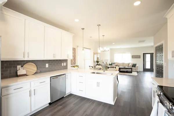 a kitchen with a sink a counter top space and living room view