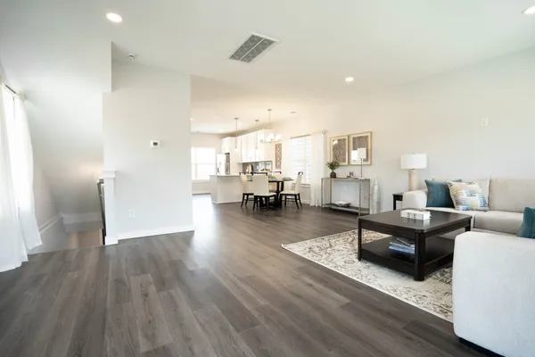 a living room with furniture and a wooden floor