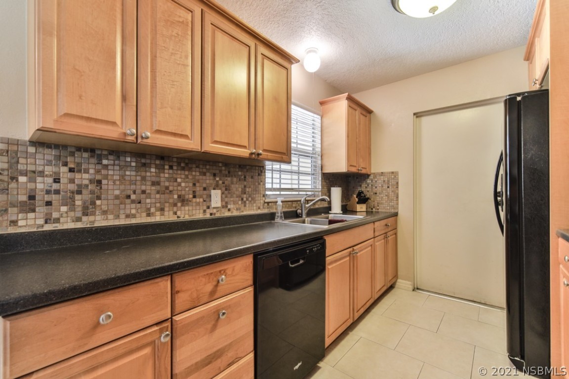 700 Green Road New Smyrna Beach, FL 32168 - Photo 16 of 37 a kitchen with stainless steel appliances granite countertop a sink stove and refrigerator