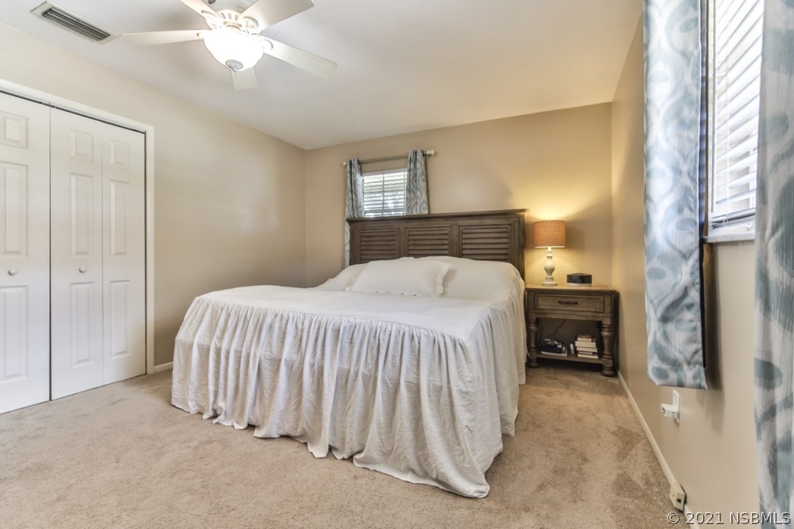 700 Green Road New Smyrna Beach, FL 32168 - Photo 22 of 37 a bedroom with a bed and a chandelier