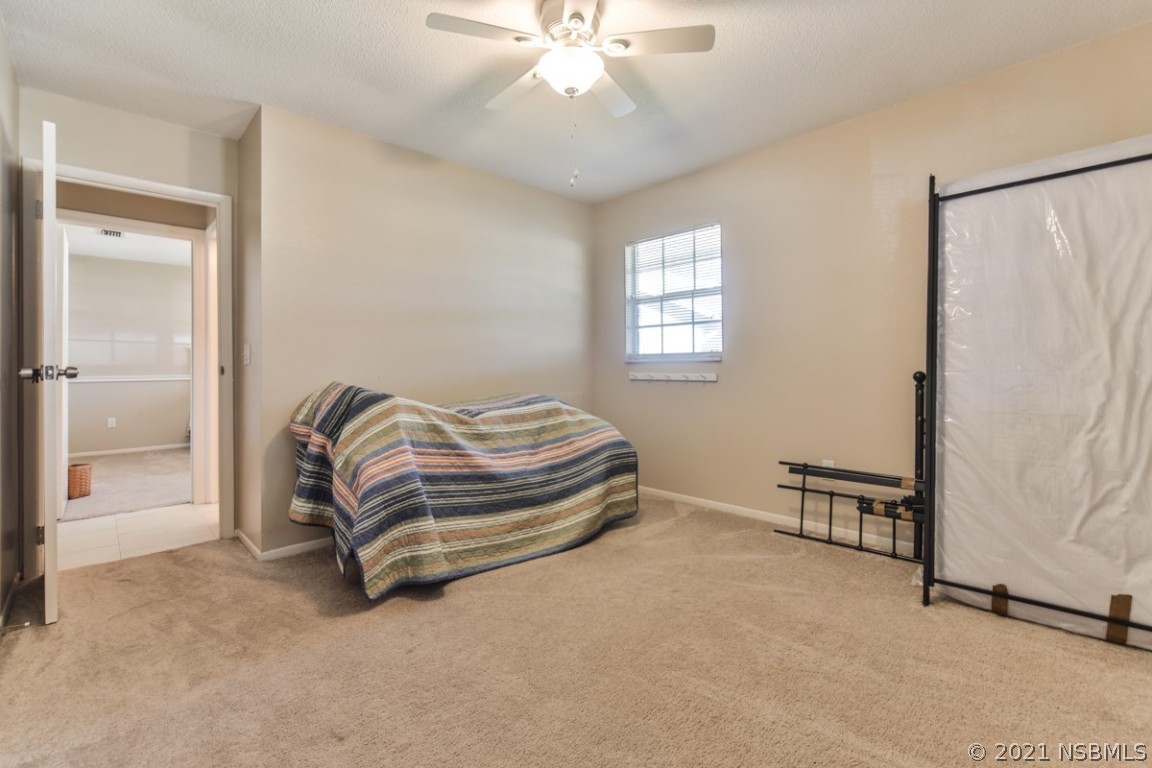 700 Green Road New Smyrna Beach, FL 32168 - Photo 26 of 37 a spacious bedroom with a bed and a chandelier