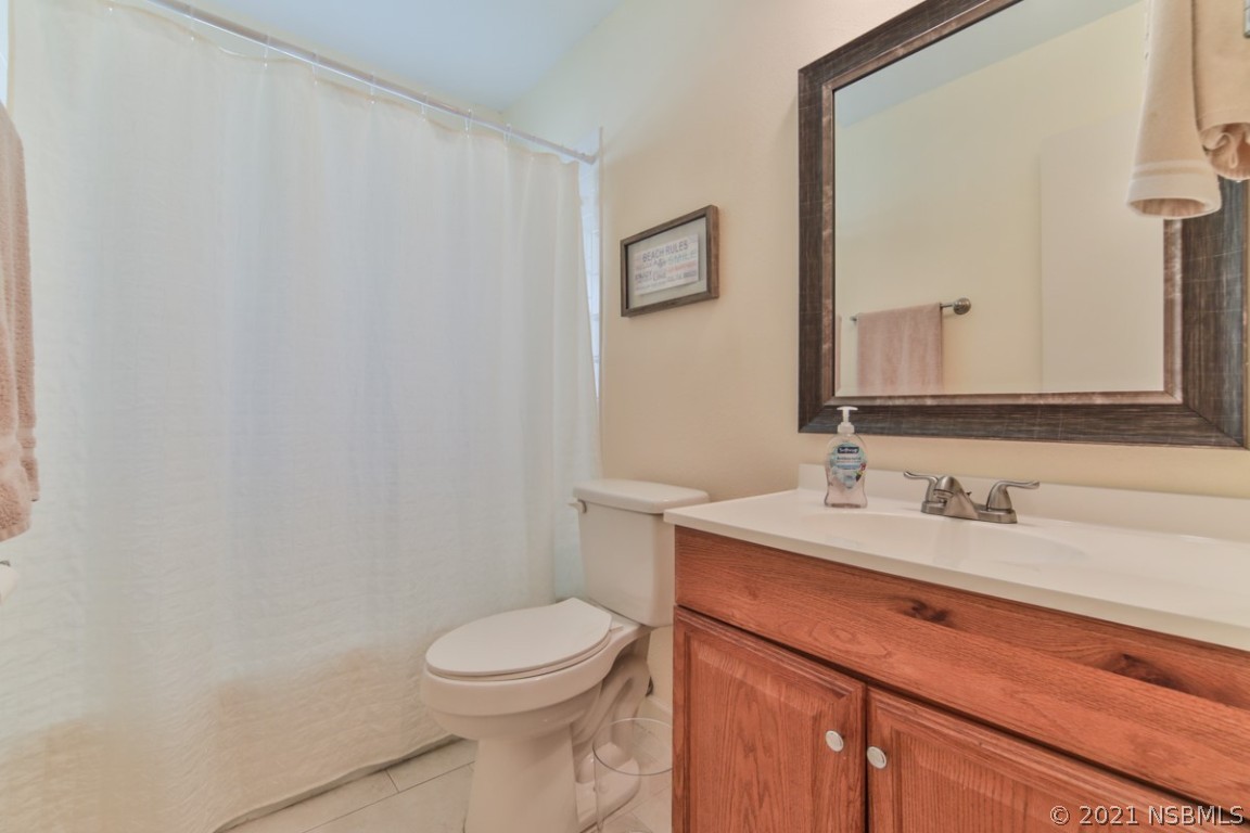 700 Green Road New Smyrna Beach, FL 32168 - Photo 28 of 37 a bathroom with a toilet a sink and mirror