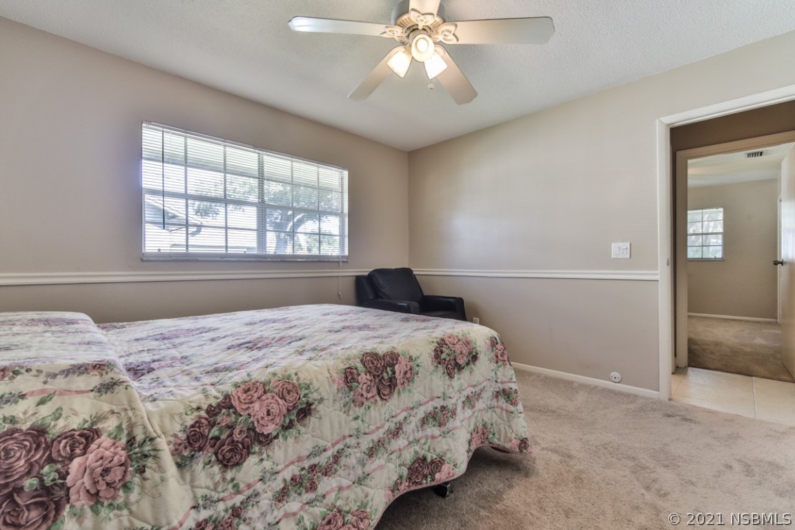 700 Green Road New Smyrna Beach, FL 32168 - Photo 30 of 37 a bedroom with a large bed and a chandelier