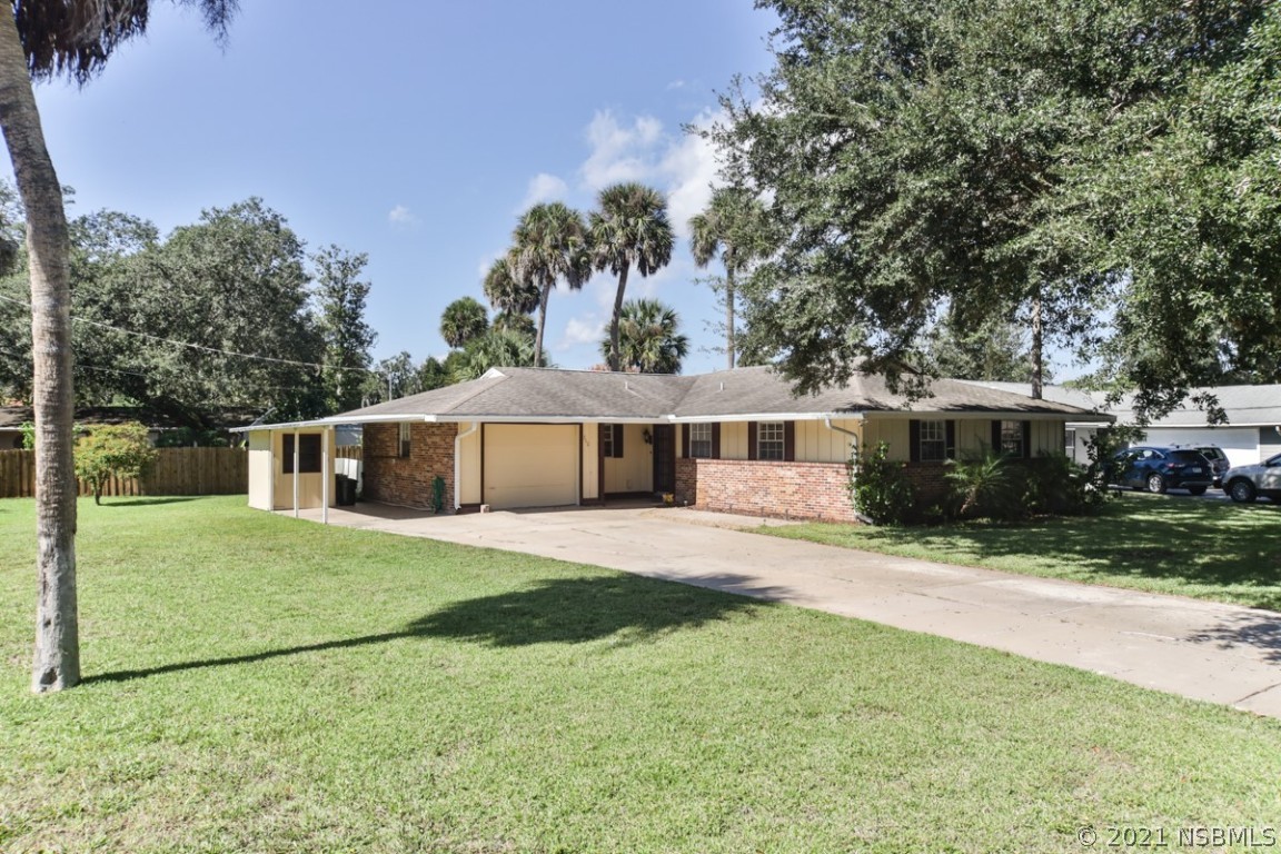 700 Green Road New Smyrna Beach, FL 32168 - Photo 5 of 37 a front view of a house with a garden