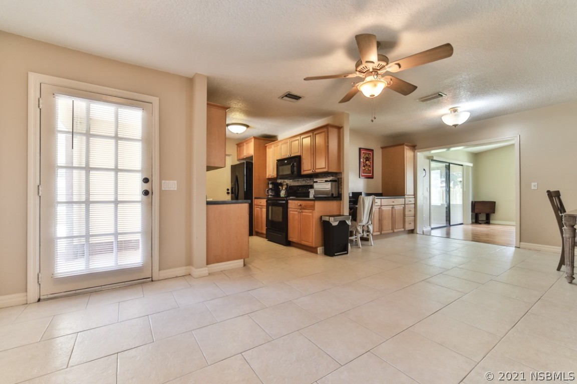700 Green Road New Smyrna Beach, FL 32168 - Photo 8 of 37 a view of a livingroom with furniture and a ceiling fan