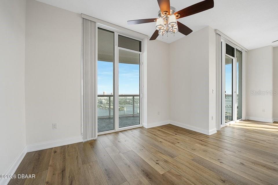 231 Riverside Drive, Unit 26011 Daytona Beach, FL 32117 - Photo 11 of 56 an empty room with wooden floor fan and windows