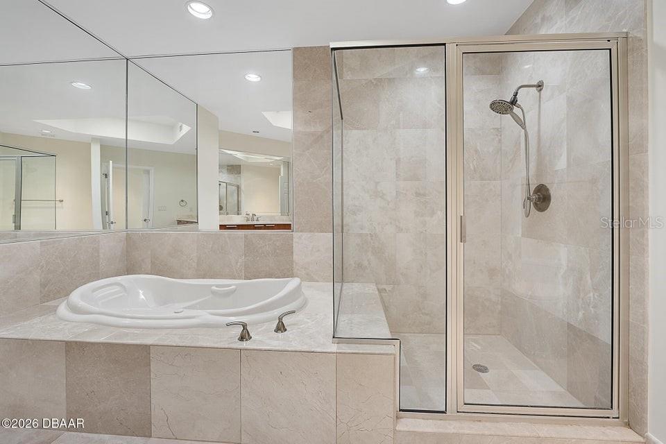 231 Riverside Drive, Unit 26011 Daytona Beach, FL 32117 - Photo 13 of 56 a bathroom with a sink a mirror and a shower