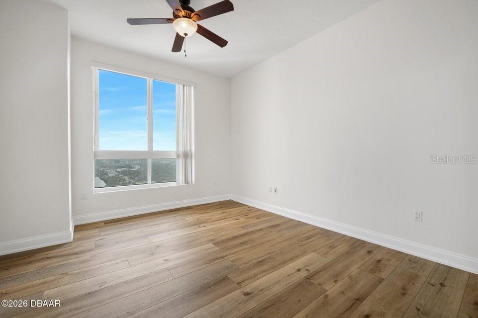 231 Riverside Drive, Unit 26011 Daytona Beach, FL 32117 - Photo 19 of 56 a view of an empty room with wooden floor and a window