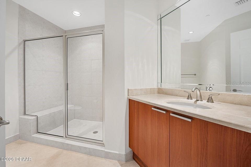 231 Riverside Drive, Unit 26011 Daytona Beach, FL 32117 - Photo 20 of 56 a bathroom with a granite countertop sink mirror and double
