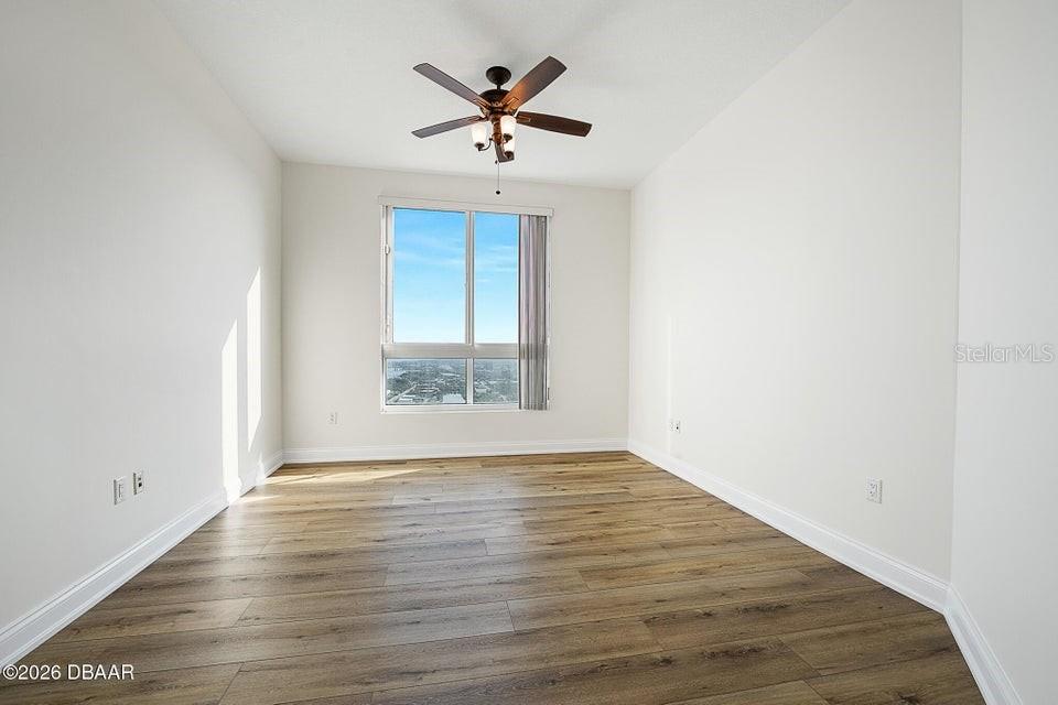 231 Riverside Drive, Unit 26011 Daytona Beach, FL 32117 - Photo 23 of 56 an empty room with wooden floor and windows
