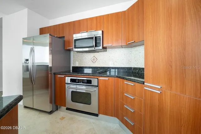 a kitchen with stainless steel appliances a sink dishwasher a stove and a refrigerator