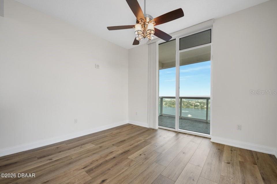 231 Riverside Drive, Unit 26011 Daytona Beach, FL 32117 - Photo 29 of 56 an empty room with wooden floor fan and windows