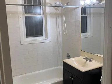 a bathroom with a sink and mirror with shower