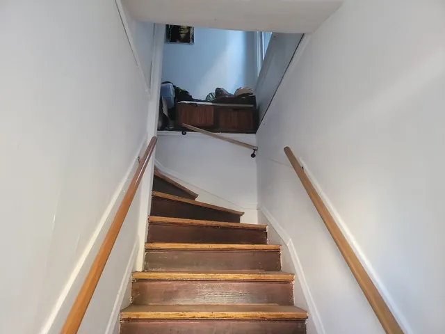 a living room with furniture kitchen view and a large window