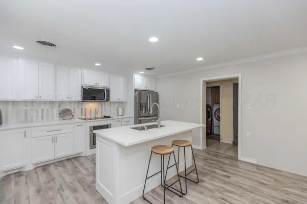 a kitchen with a sink stove top oven and refrigerator