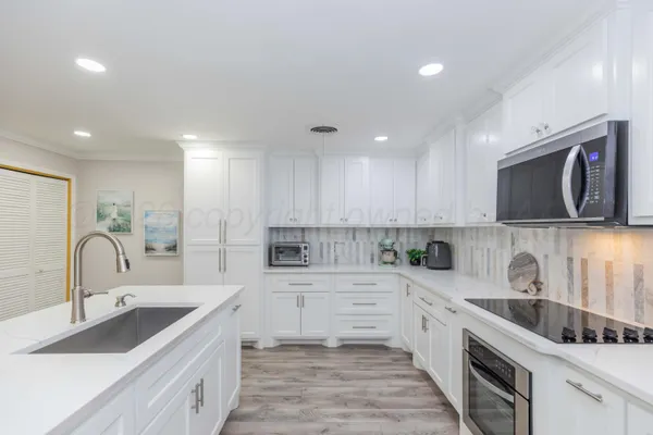 a kitchen with white cabinets sink and center island
