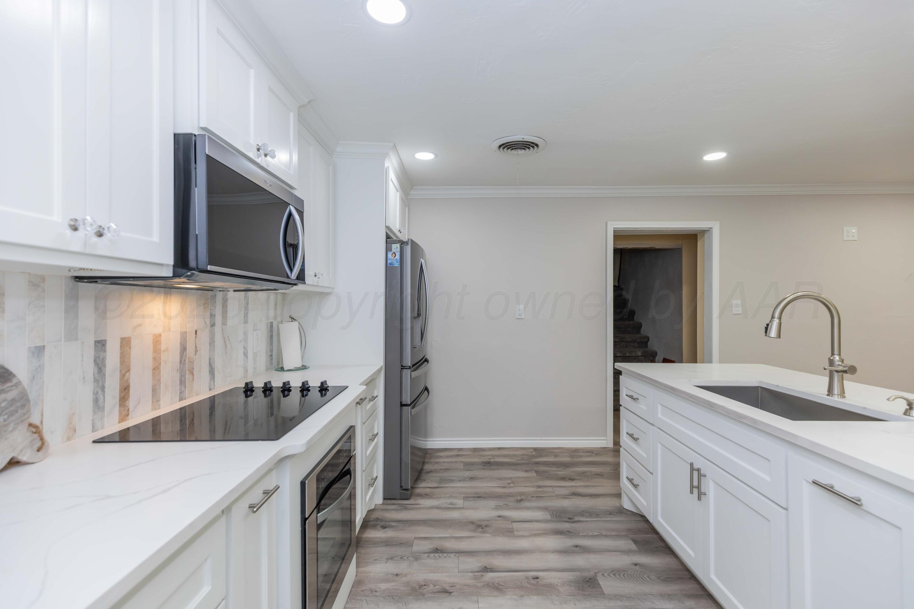 905 North Travis Street Amarillo, TX 79107 - Photo 16 of 42 a kitchen with stainless steel appliances granite countertop a sink stove and refrigerator
