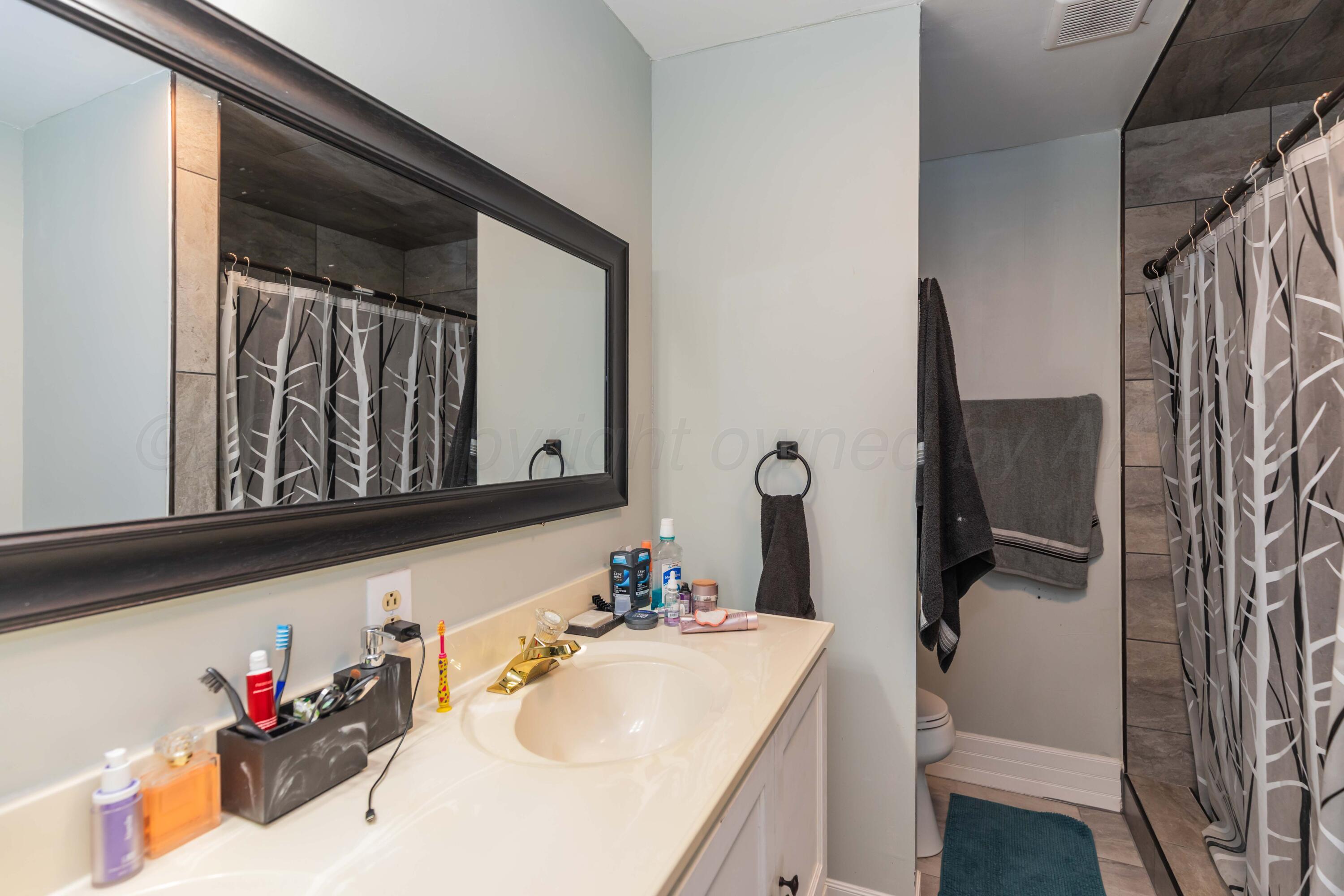 905 North Travis Street Amarillo, TX 79107 - Photo 22 of 42 a bathroom with a sink and a mirror