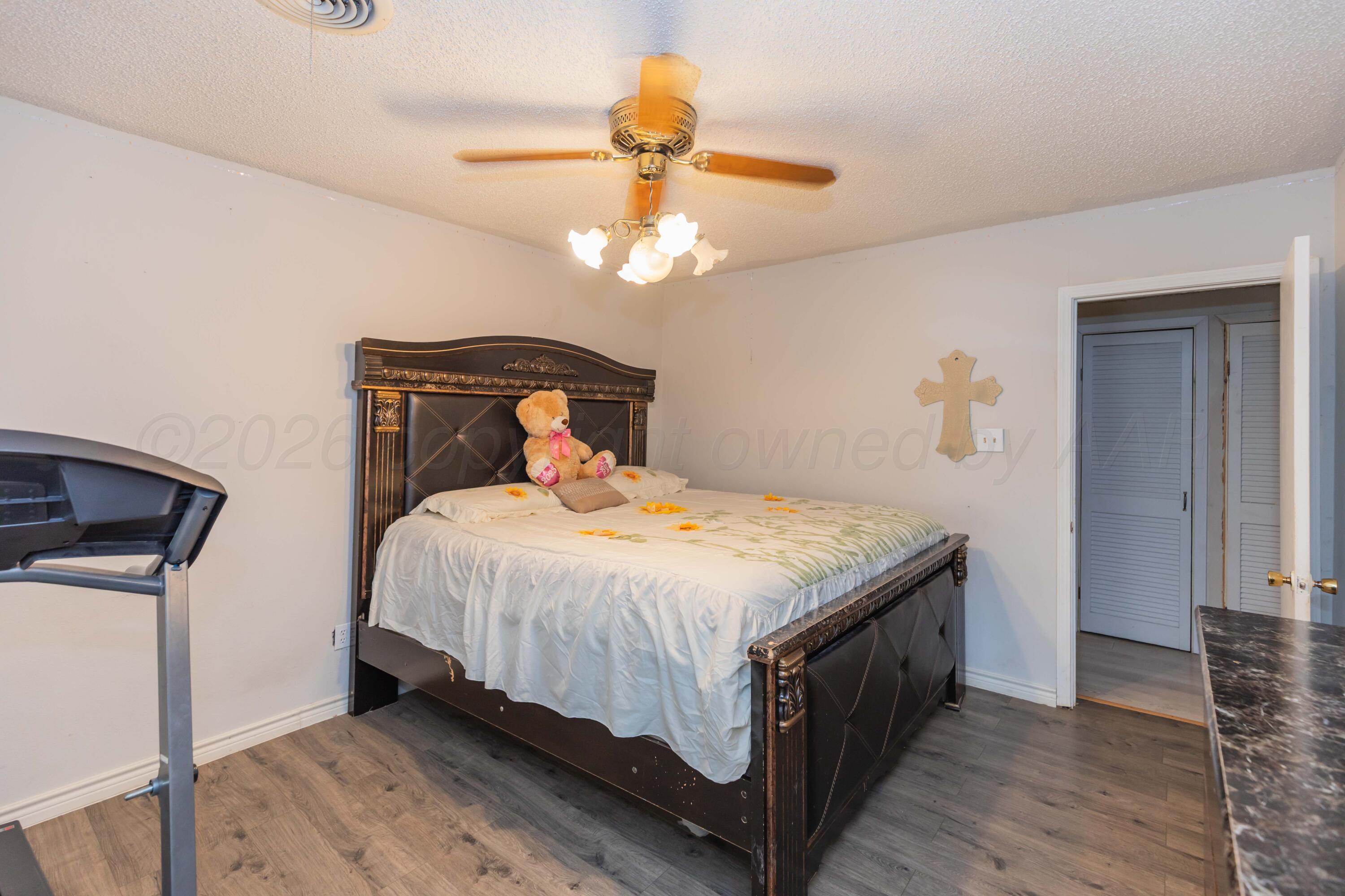 905 North Travis Street Amarillo, TX 79107 - Photo 30 of 42 a bedroom with a bed and a chandelier