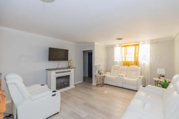 a living room with furniture a flat screen tv and a fireplace