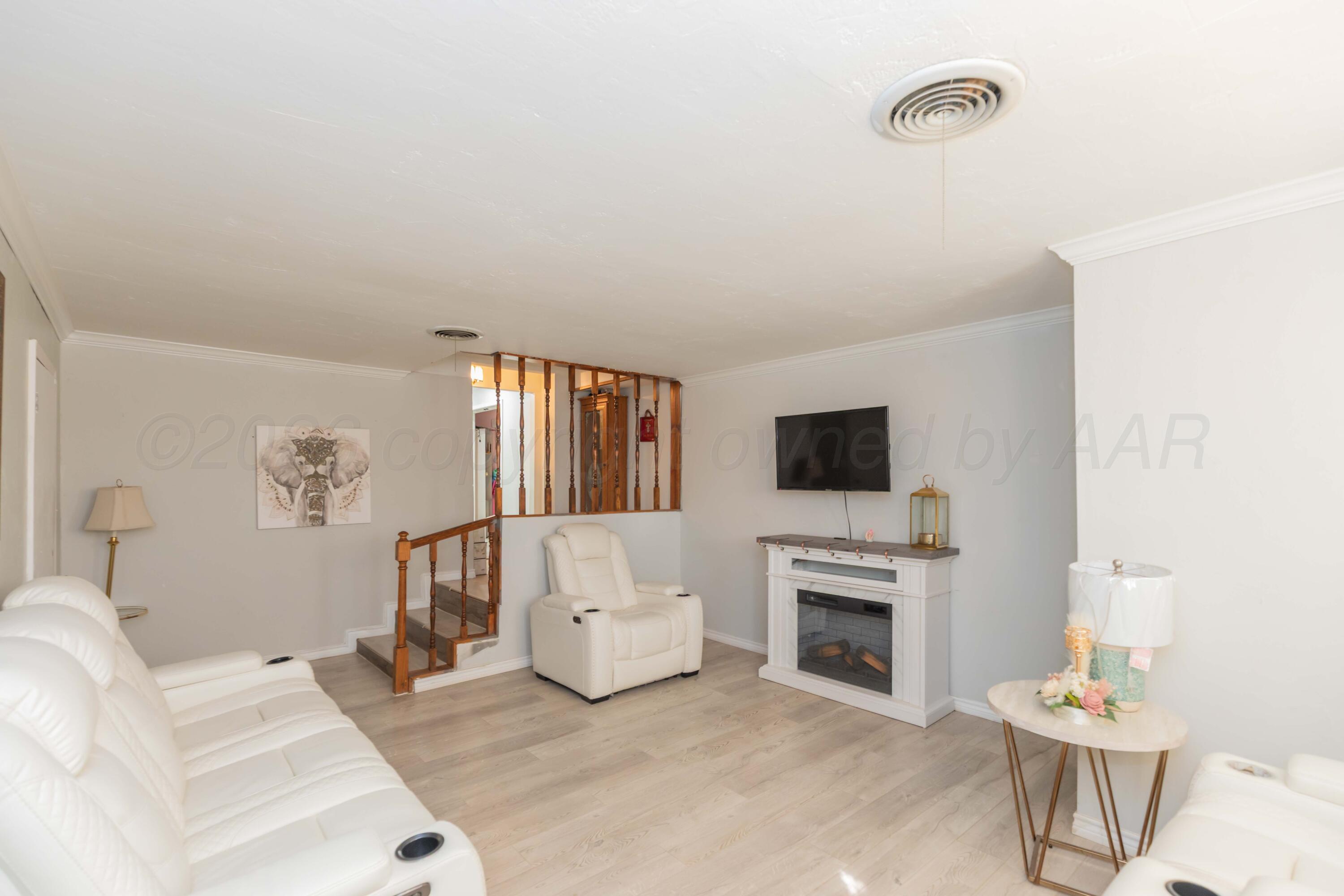 905 North Travis Street Amarillo, TX 79107 - Photo 6 of 42 a living room with furniture a flat screen tv and a fireplace