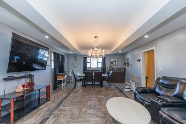 a living room with furniture and a chandelier