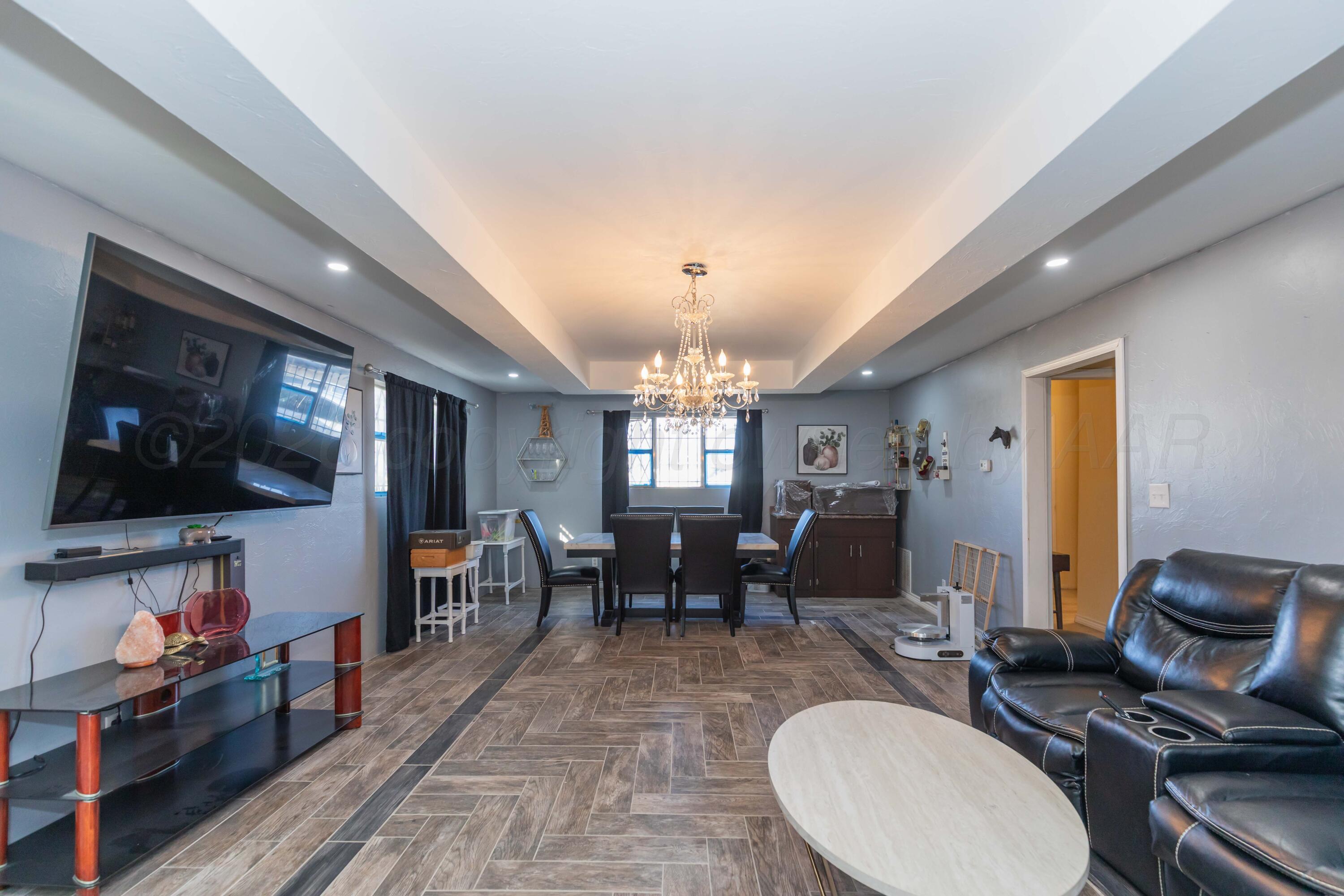905 North Travis Street Amarillo, TX 79107 - Photo 7 of 42 a living room with furniture a flat screen tv and kitchen view