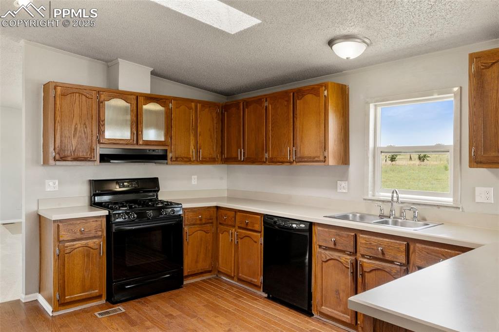 34535 Big Springs Road Yoder, CO 80864 - Photo 10 of 34 a kitchen with stainless steel appliances granite countertop a stove a sink dishwasher and a microwave oven with wooden cabinets