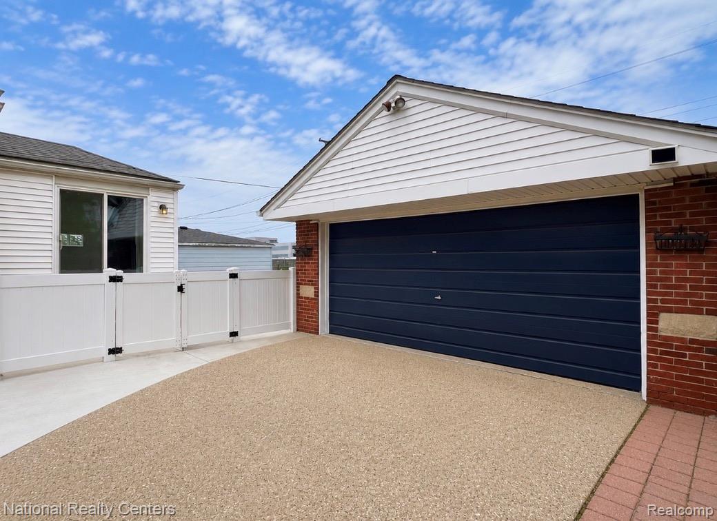 7285 Helen Street Center Line, MI 48015 - Photo 27 of 32 Detached garage with a dark blue garage door, white siding, and a brick facade accent