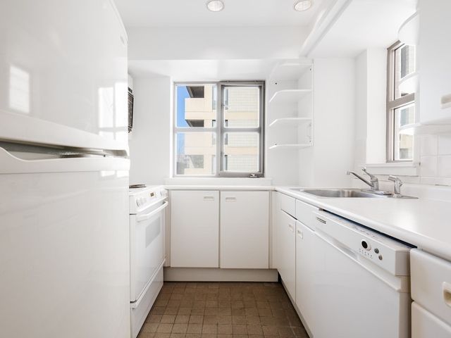 a utility room with cabinets washer and dryer