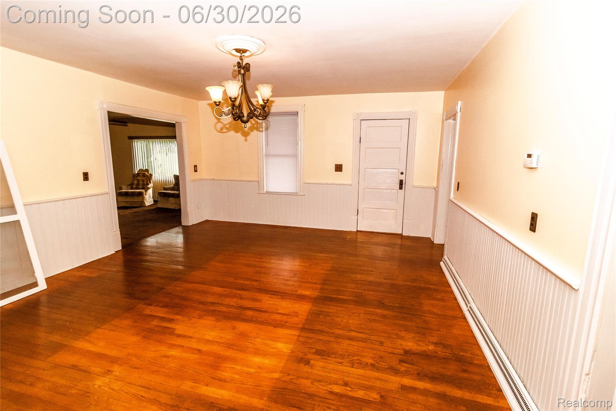 8150 Norman Road Imlay City, MI 48444 - Photo 15 of 58 Hardwood flooring featuring an overhead chandelier, beadboard wainscoting, and a paneled interior door