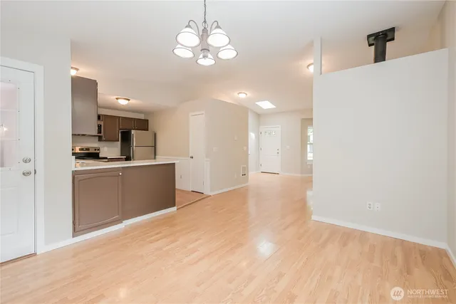 a view of a kitchen with a sink and dishwasher a refrigerator with wooden floor
