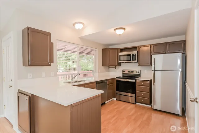a kitchen with refrigerator cabinets and wooden floor