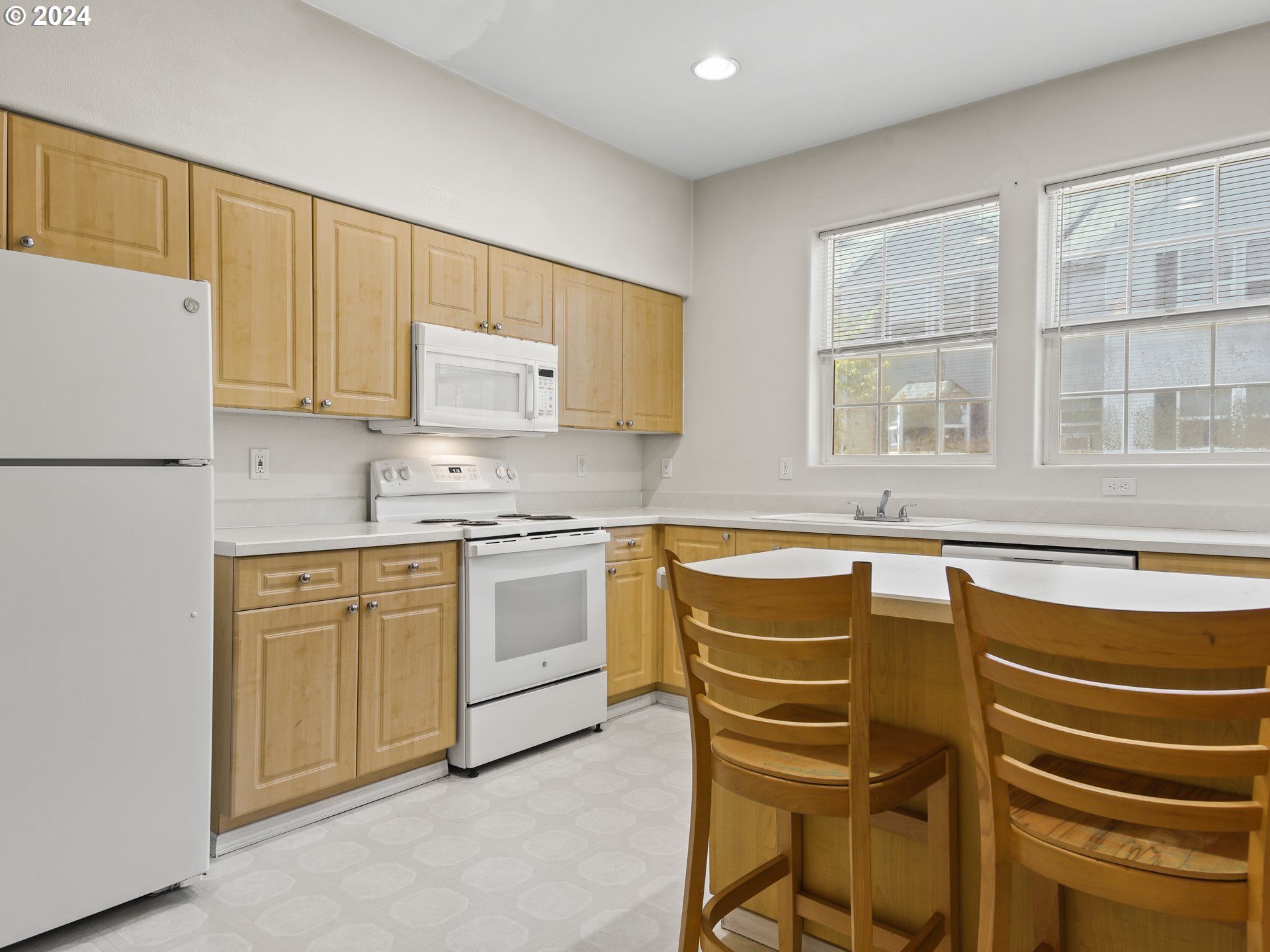 14315 Southwest Cougar Ridge Drive Beaverton, OR 97008 - Photo 6 of 21 a kitchen with stainless steel appliances granite countertop a stove a sink and a refrigerator with wooden floors