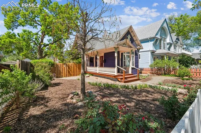 a view of a house with backyard and trees