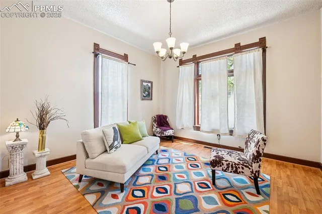 a living room with patio furniture and a chandelier