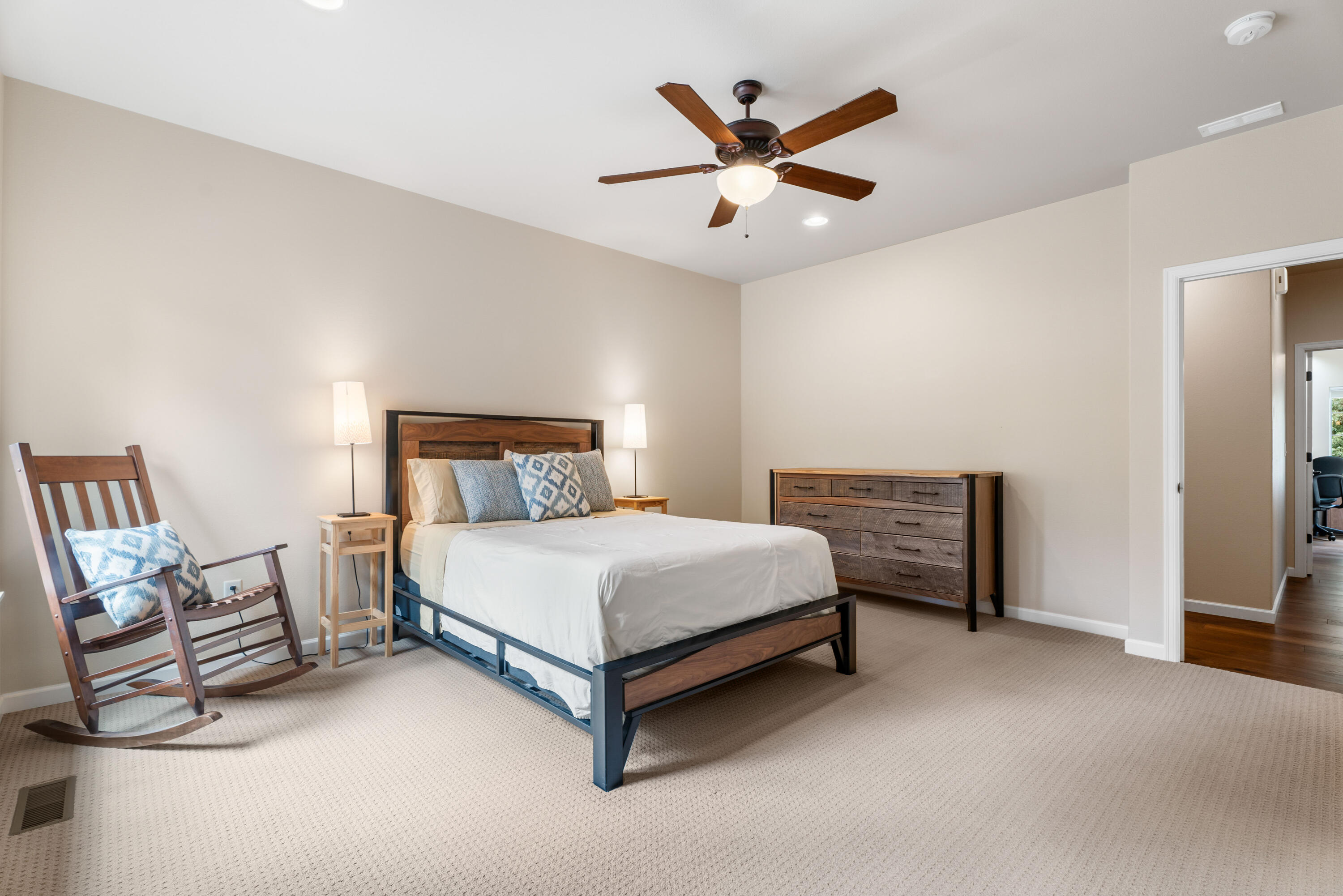 205 Vista Rim Drive Redmond, OR 97756 - Photo 30 of 85 a spacious bedroom with a bed and a chandelier