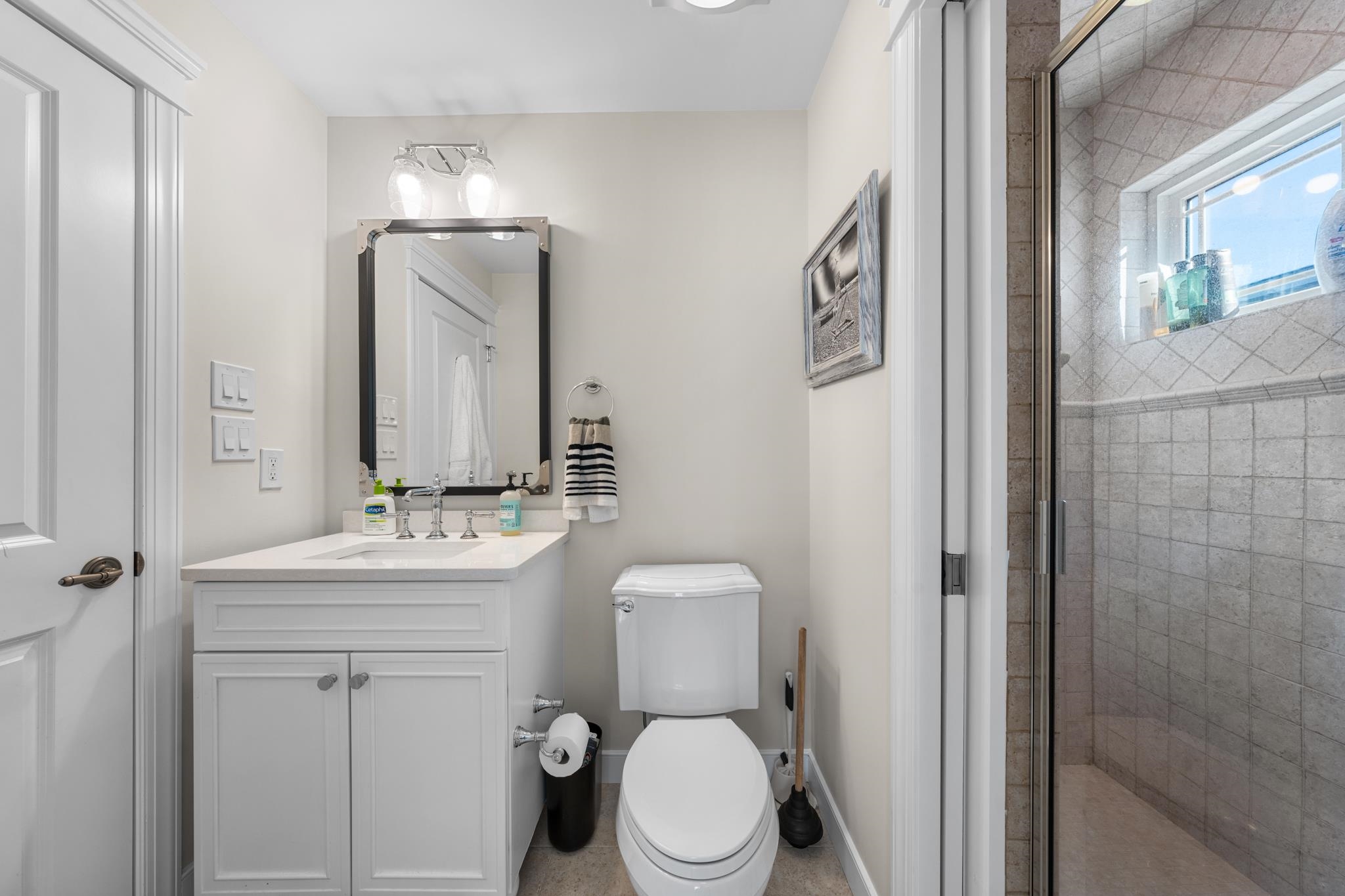 40 13th Street East Avalon, NJ 08202 - Photo 35 of 40 a bathroom with a toilet a sink a mirror a vanity and shower
