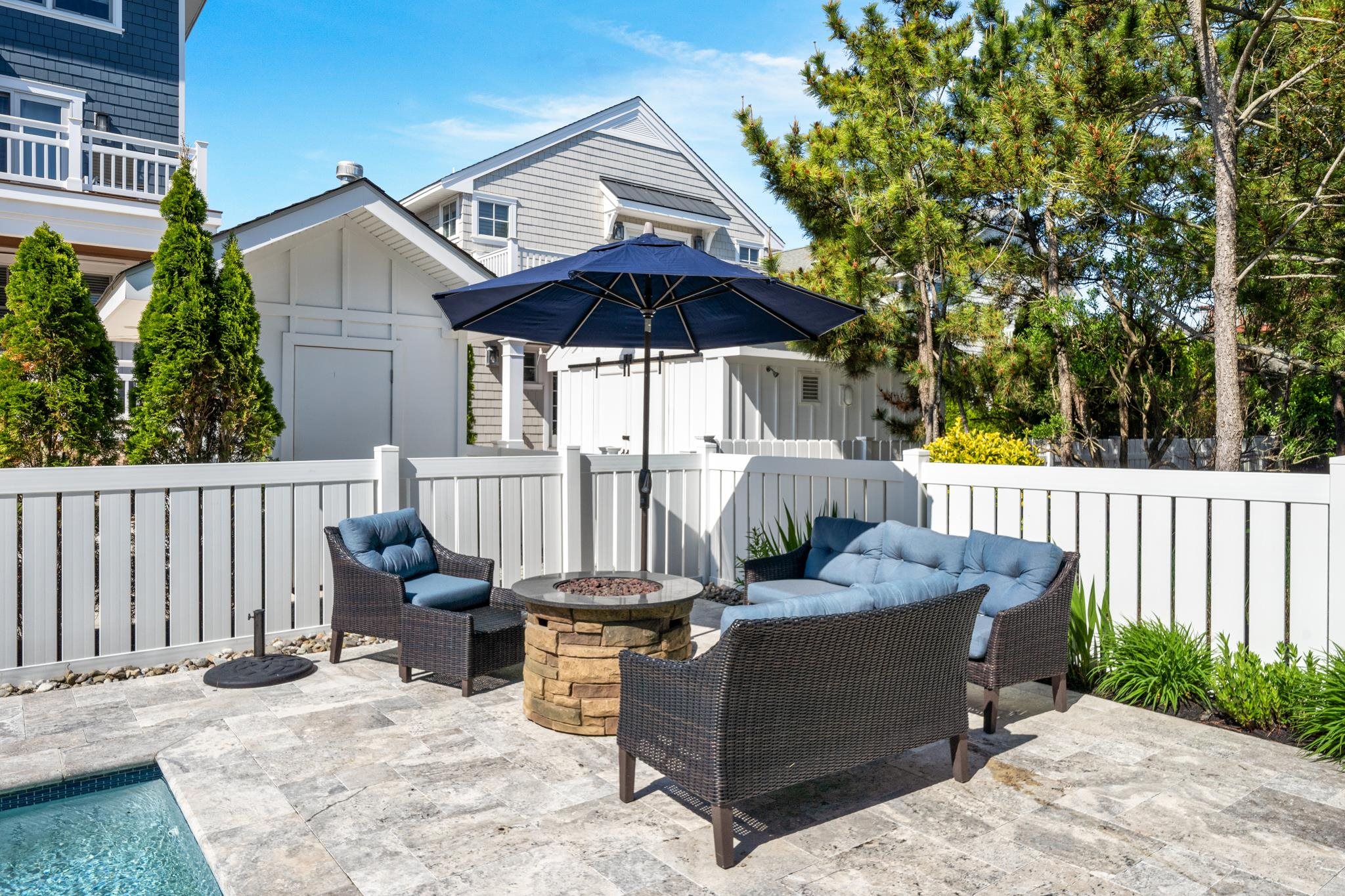 40 13th Street East Avalon, NJ 08202 - Photo 10 of 40 a view of a patio with a table and chairs under an umbrella