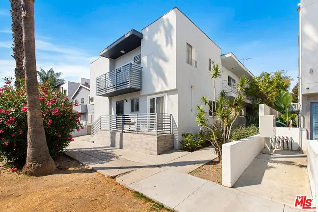 a view of a white house with a yard and plants